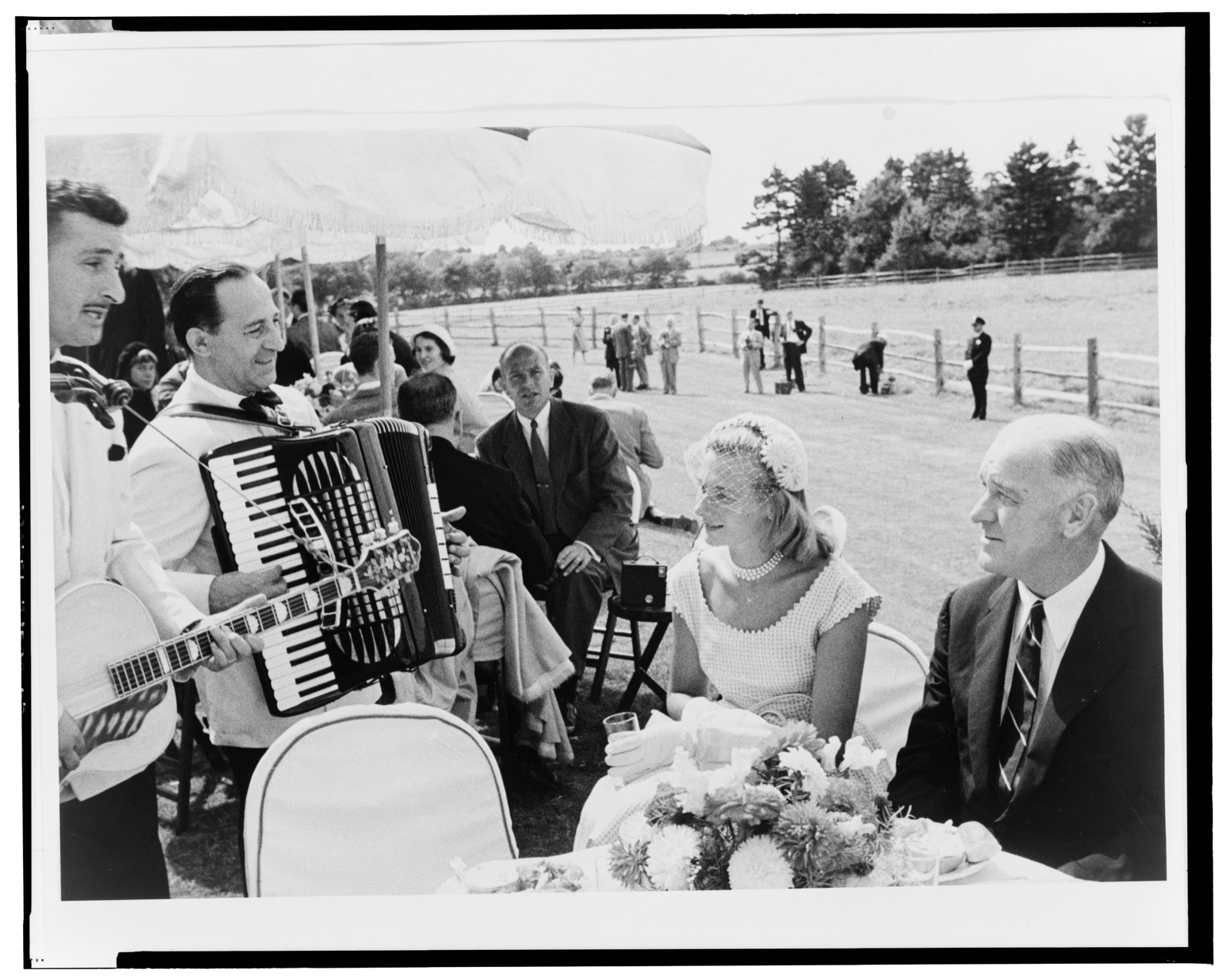 [Guests at the Bouvier-Kennedy wedding reception, being entertained by musicians] — Frissell, Toni, 1907-1988