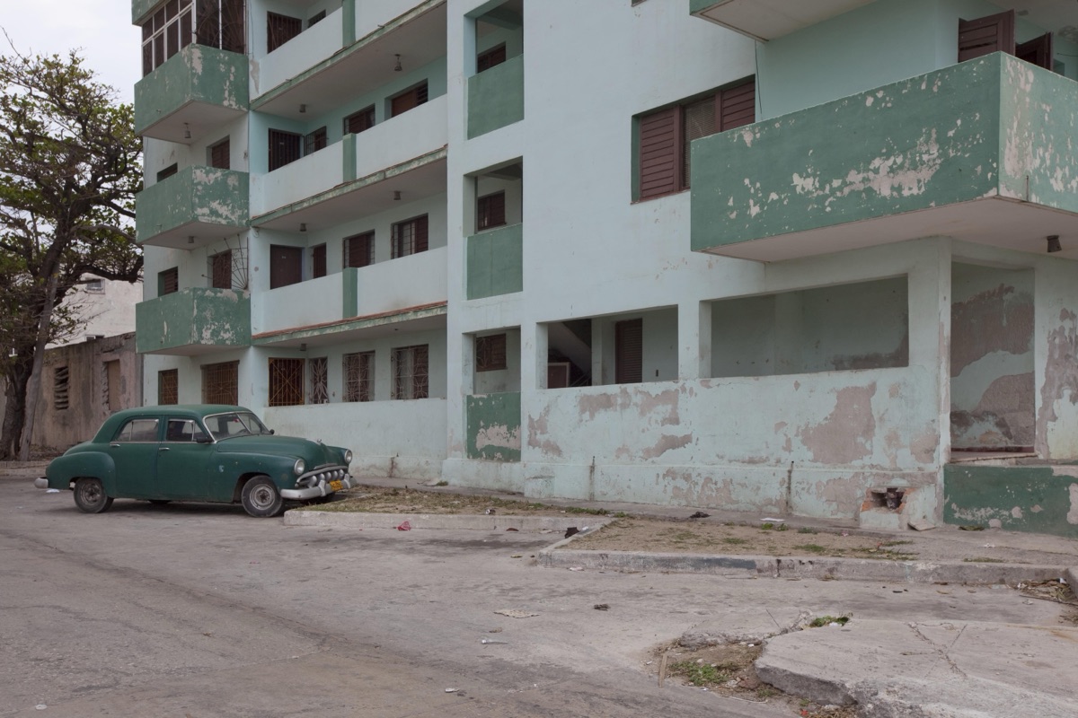 Vintage car matches the color of the building off the Malecón in Havana, Cuba