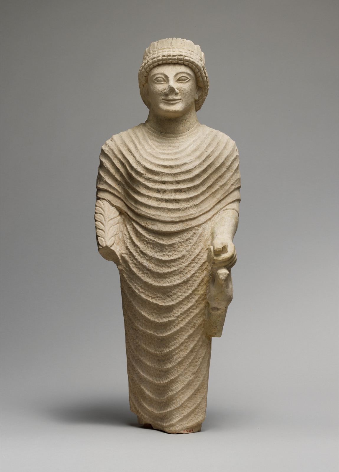 Limestone statue of a male votary holding a bird in the left hand